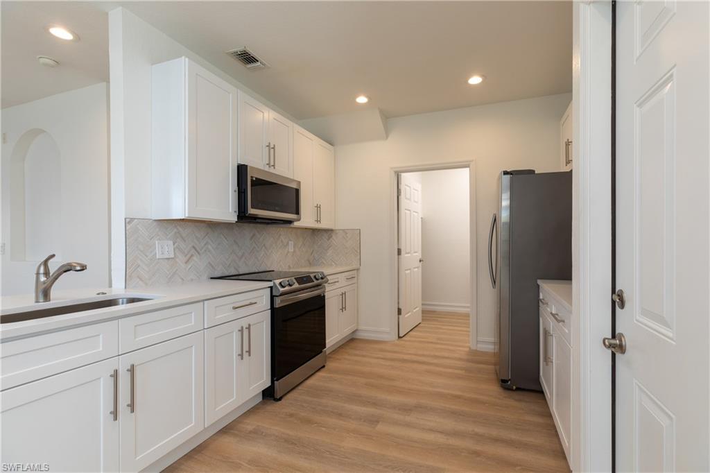 15618 Summit Pl Circle, Unit 396 Naples, FL 34119 - Photo 6 of 41 a kitchen with stainless steel appliances granite countertop a refrigerator stove microwave and sink