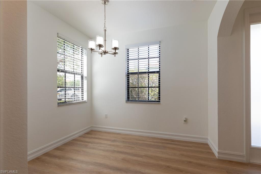 15618 Summit Pl Circle, Unit 396 Naples, FL 34119 - Photo 8 of 41 a view of an empty room with wooden floor and a window