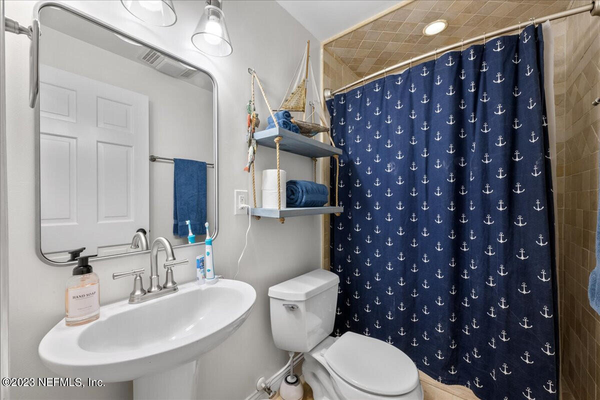 174 Eventide Drive Fleming Island, FL 32003 - Photo 21 of 24 a bathroom with a toilet a sink and mirror