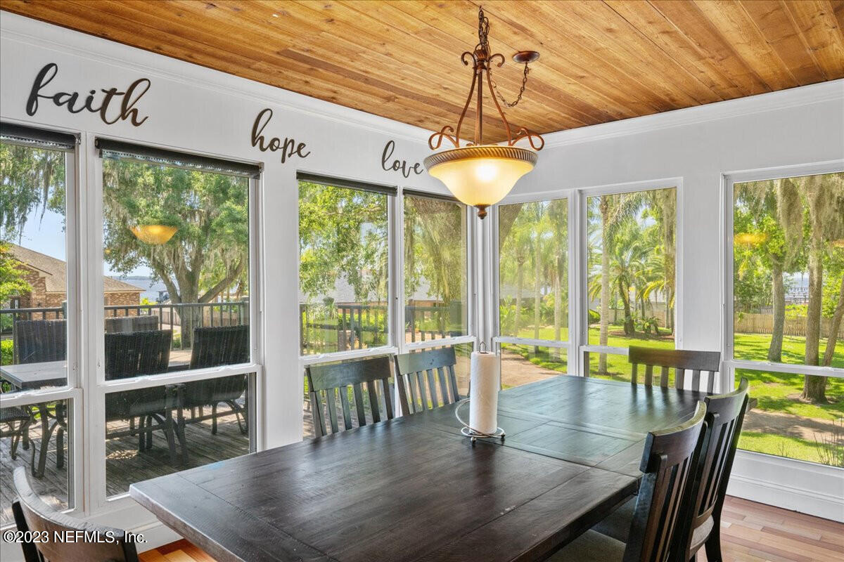 174 Eventide Drive Fleming Island, FL 32003 - Photo 9 of 24 a view of a dining room with furniture large windows and wooden floor