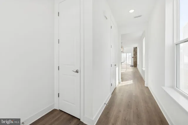 a view of a hallway with wooden floor