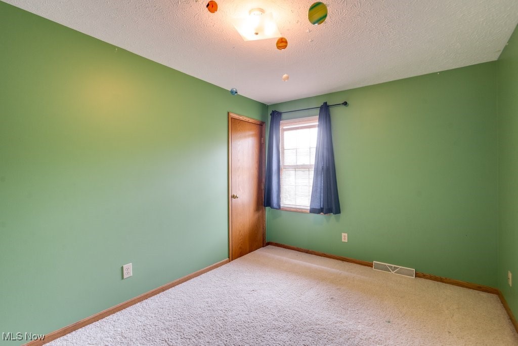 5613 Stoney Ridge Road Northwest Canton, OH 44718 - Photo 17 of 39 Unfurnished room featuring a textured ceiling and carpet