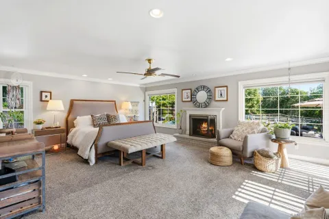 a spacious bedroom with furniture and a fireplace
