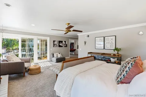 a spacious bedroom with a bed a couch and a large window