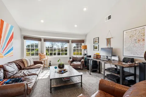 a living room with furniture fireplace and a large window