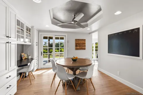 a dining room with furniture wooden floor a rug and a painting