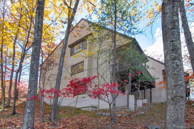 a view of a house with a yard and large tree