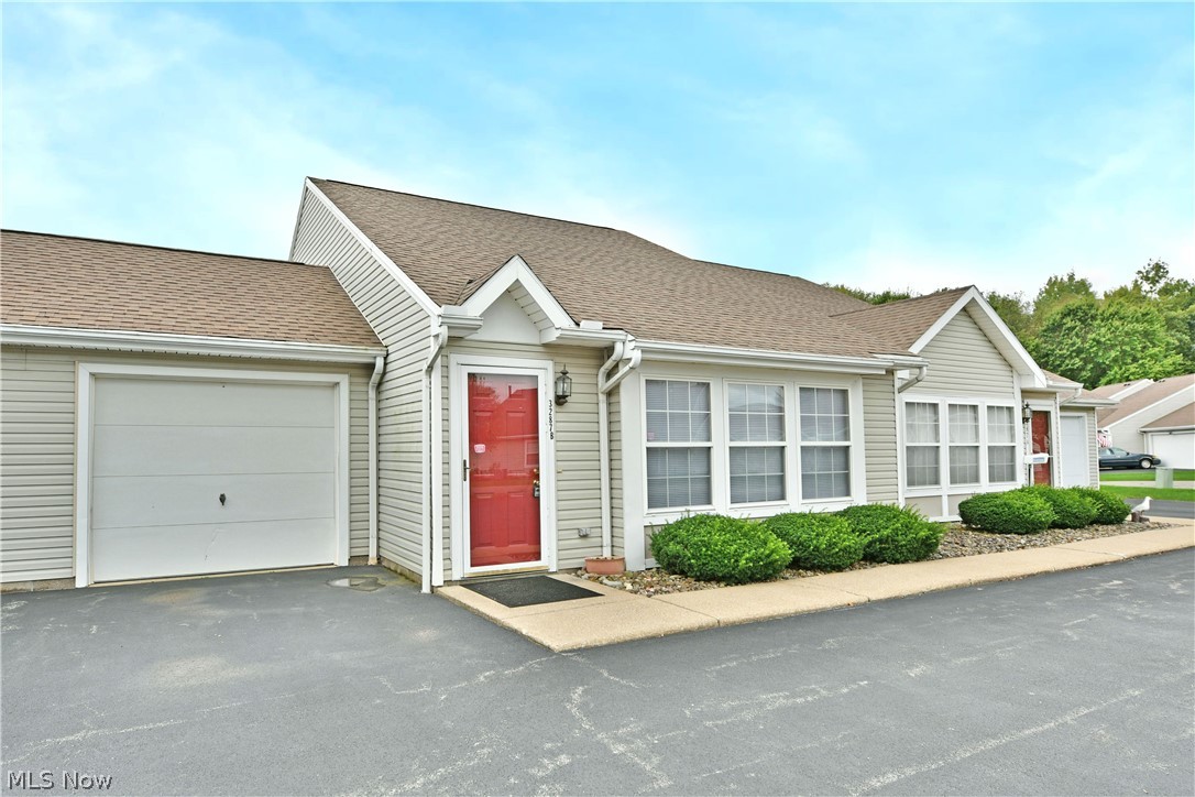 3287 Pheasant Run Road, Unit B Cortland, OH 44410 - Photo 5 of 45 Siding exterior with an attached garage, covered entryway, and front landscaping