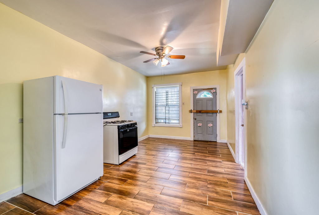 1738 North Harding Avenue Chicago, IL 60647 - Photo 13 of 21 a view of a kitchen with a refrigerator a ceiling fan and a wooden floor