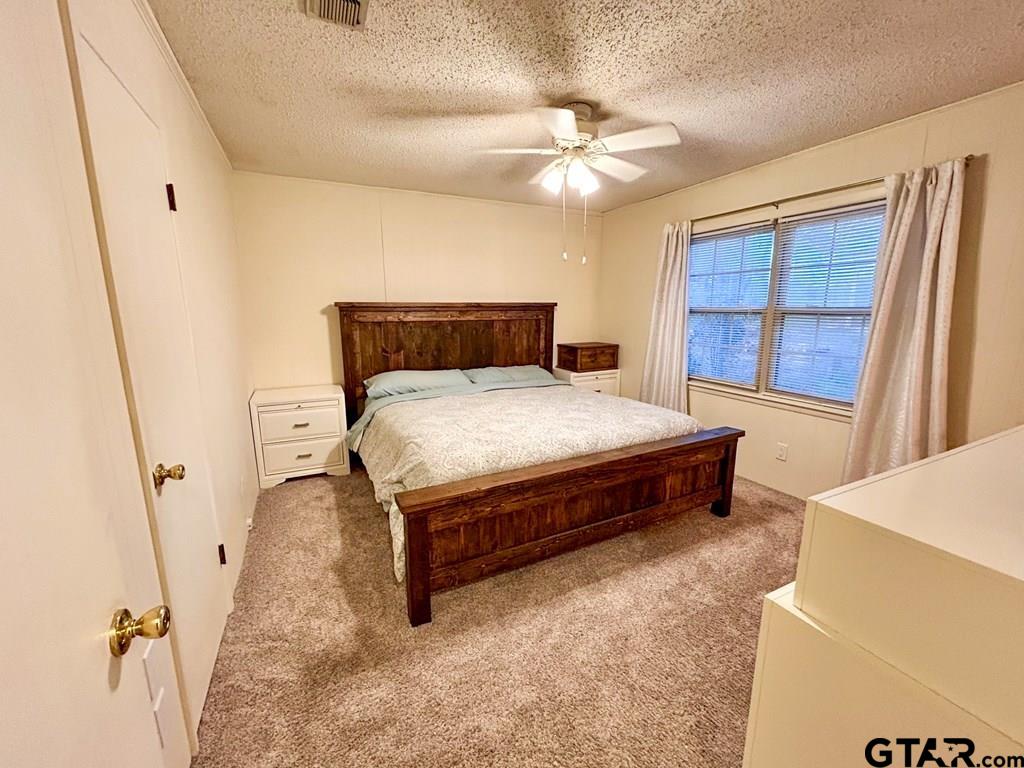 213 Sherry Lane Palestine, TX 75803 - Photo 11 of 25 a bedroom with a bed and a chandelier