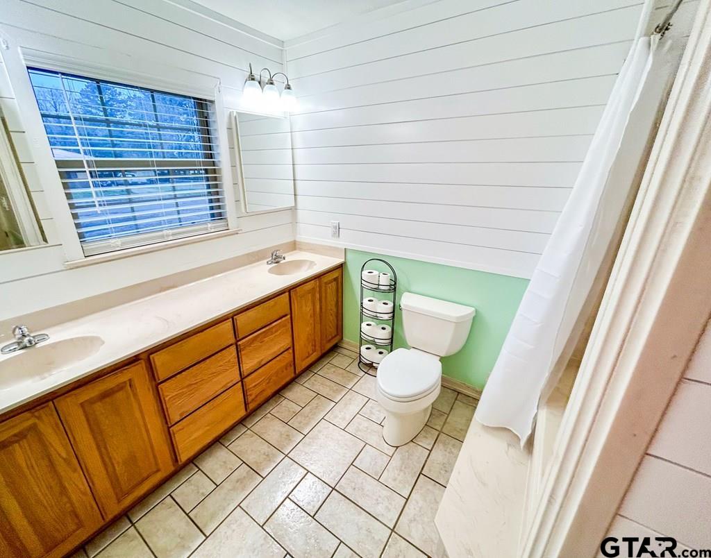 213 Sherry Lane Palestine, TX 75803 - Photo 12 of 25 a bathroom with a sink a toilet a vanity and window