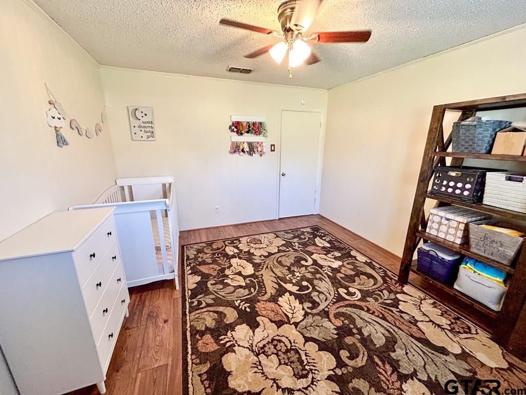 213 Sherry Lane Palestine, TX 75803 - Photo 18 of 25 a bedroom with a bed and wooden floor