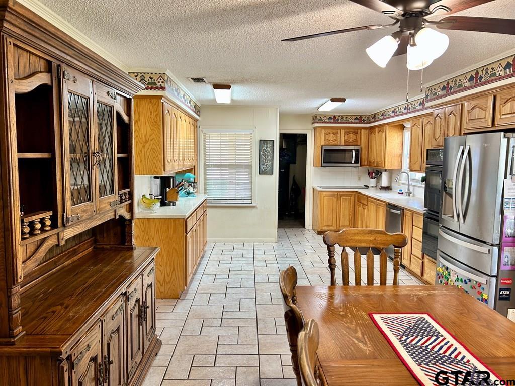 213 Sherry Lane Palestine, TX 75803 - Photo 5 of 25 a kitchen with stainless steel appliances granite countertop a refrigerator a stove and a dining table with wooden floor