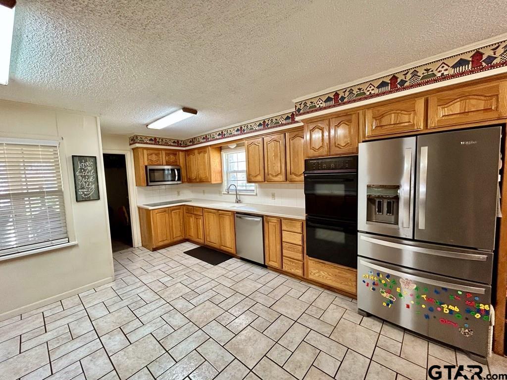 213 Sherry Lane Palestine, TX 75803 - Photo 6 of 25 a kitchen with stainless steel appliances granite countertop a refrigerator and a sink