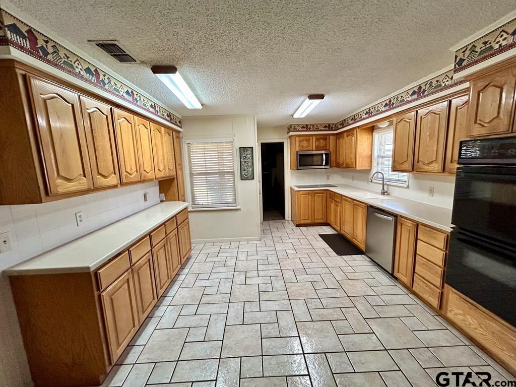 213 Sherry Lane Palestine, TX 75803 - Photo 7 of 25 a kitchen with stainless steel appliances granite countertop a sink and cabinets