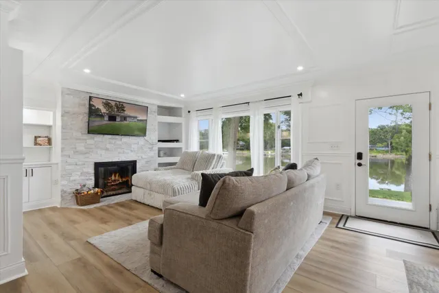 a living room with furniture a fireplace and a large window