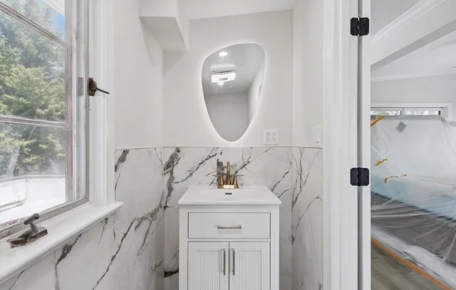 a bathroom with a sink a toilet and a mirror