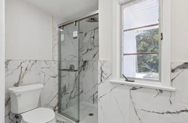 a bathroom with a toilet and a shower