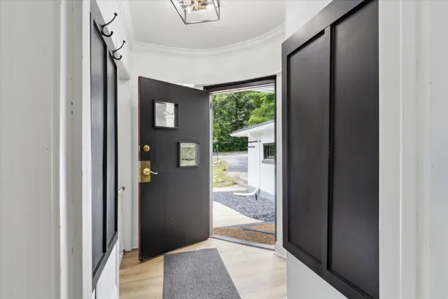 a view of a hallway view with wooden floor and a livingroom