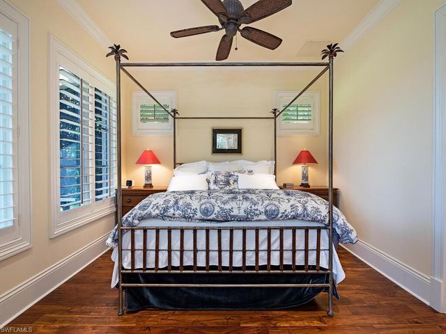 a view of a patio with table and chairs under an umbrella with a barbeque