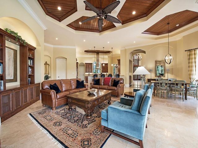 a dining room filled chandelier and kitchen view