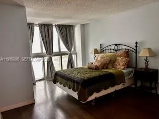 a bedroom with a bed a window with wooden floor