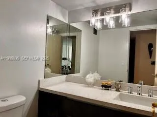 a bathroom with a sink a toilet and a mirror