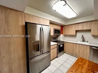 a kitchen with stainless steel appliances a refrigerator sink and microwave