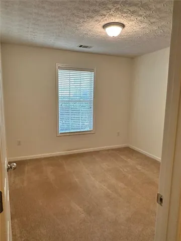 a view of empty room with window and wooden floor