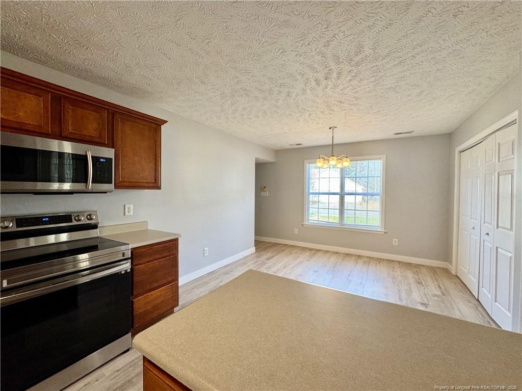 5503 Rising Ridge Drive Hope Mills, NC 28348 - Photo 7 of 18 a kitchen with stainless steel appliances a stove microwave and sink