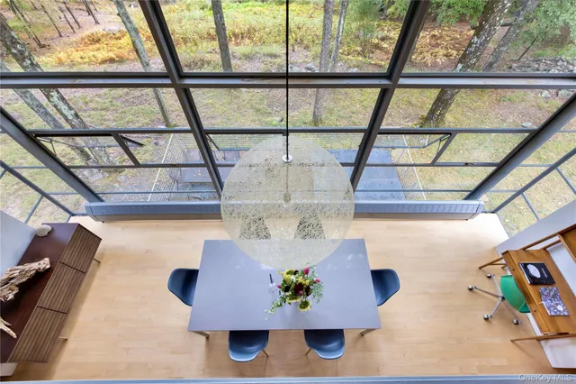 a dining room with wooden floor and a floor to ceiling window
