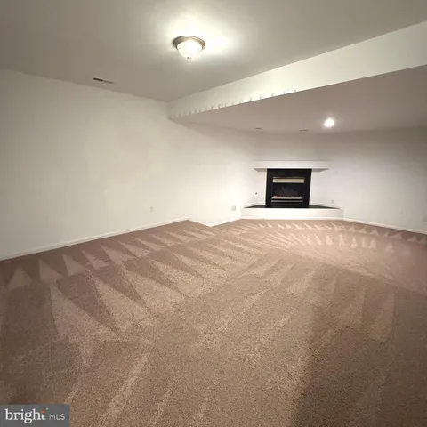 an empty room with windows and fireplace