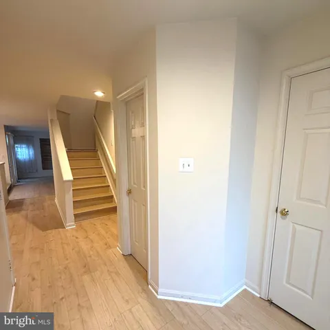 a view of a hallway with entryway wooden floor and front door