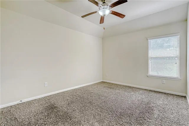 an empty room with fan and windows