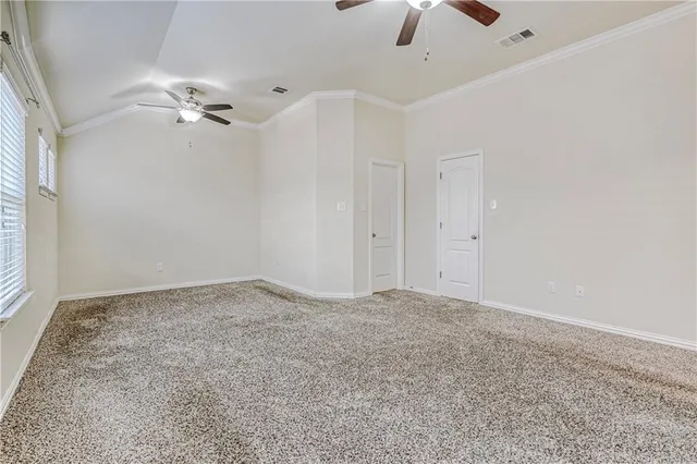 an empty room with chandelier fan