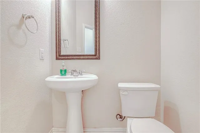 a bathroom with a sink a toilet and mirror