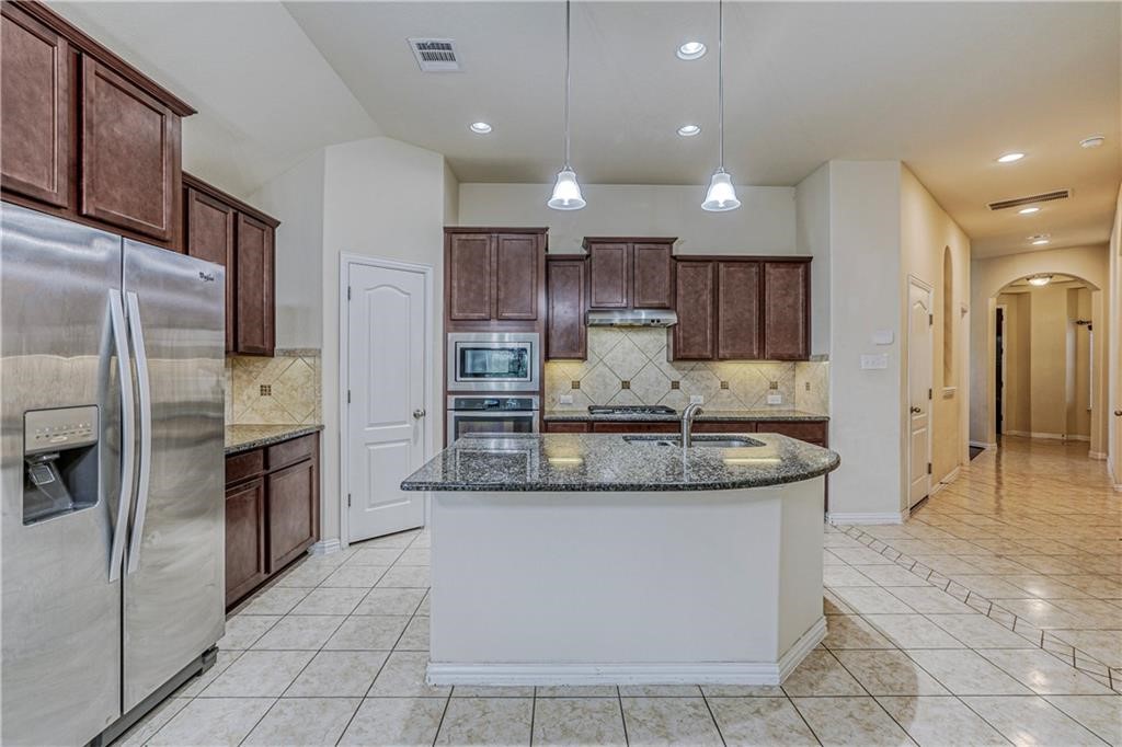 3517 Grail Hollows Road Pflugerville, TX 78660 - Photo 29 of 40 a large kitchen with a stove a refrigerator and a sink