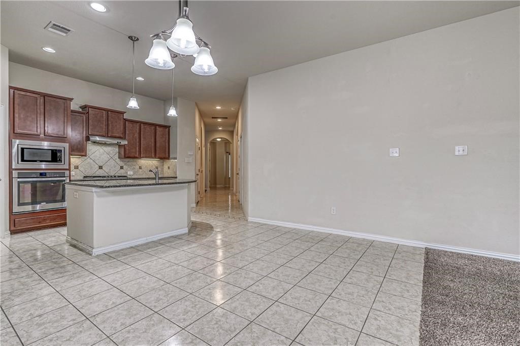 3517 Grail Hollows Road Pflugerville, TX 78660 - Photo 31 of 40 a kitchen with kitchen island granite countertop stainless steel appliances cabinets a sink and a counter top