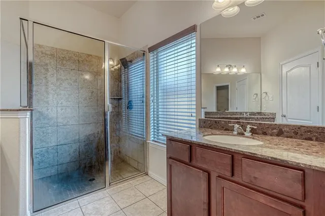 a bathroom with a shower sink and mirror