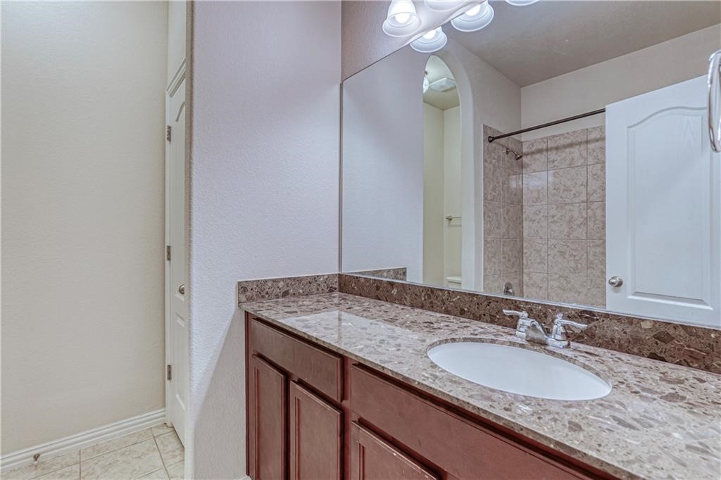 3517 Grail Hollows Road Pflugerville, TX 78660 - Photo 10 of 40 a bathroom with a granite countertop sink and a mirror