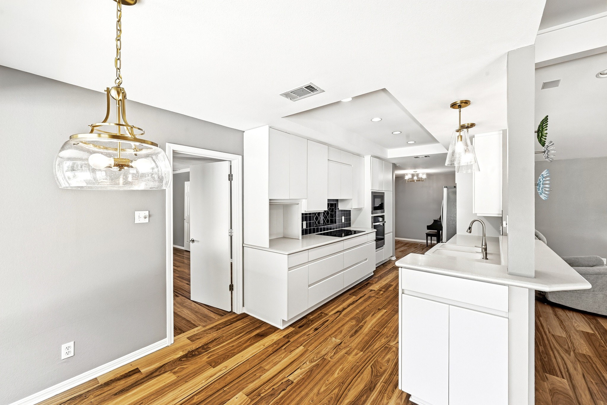 8608 Crest Ridge Circle Austin, TX 78750 - Photo 15 of 38 Warm wood flooring extends throughout this modern kitchen with crisp white cabinetry and a convenient breakfast bar.