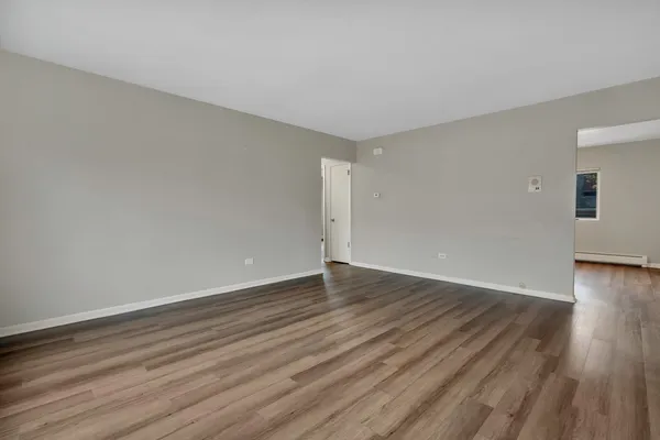 a view of an empty room with wooden floor