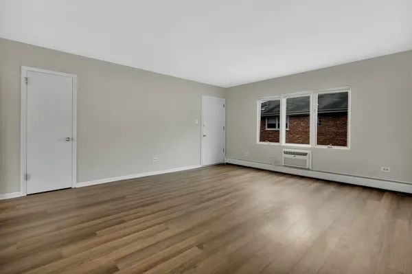 a view of a room with wooden floor and window