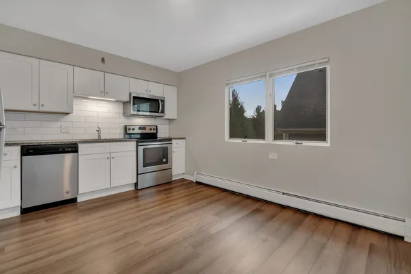 a kitchen with granite countertop white cabinets and stainless steel appliances