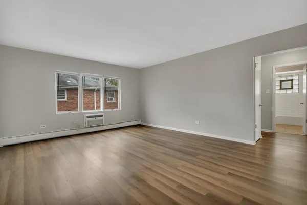 a view of a room with wooden floor and windows