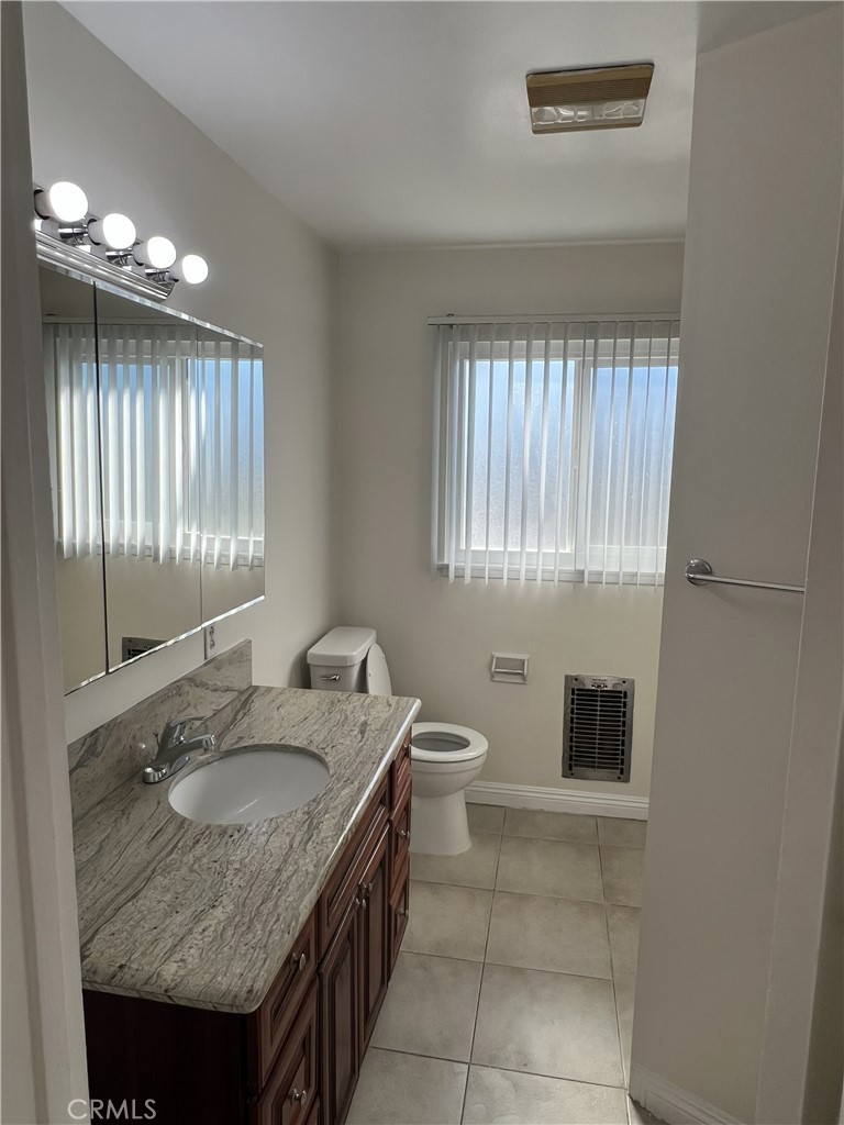 401 West Grand Avenue, Unit C Alhambra, CA 91801 - Photo 11 of 14 a bathroom with a granite countertop sink a toilet a mirror and window