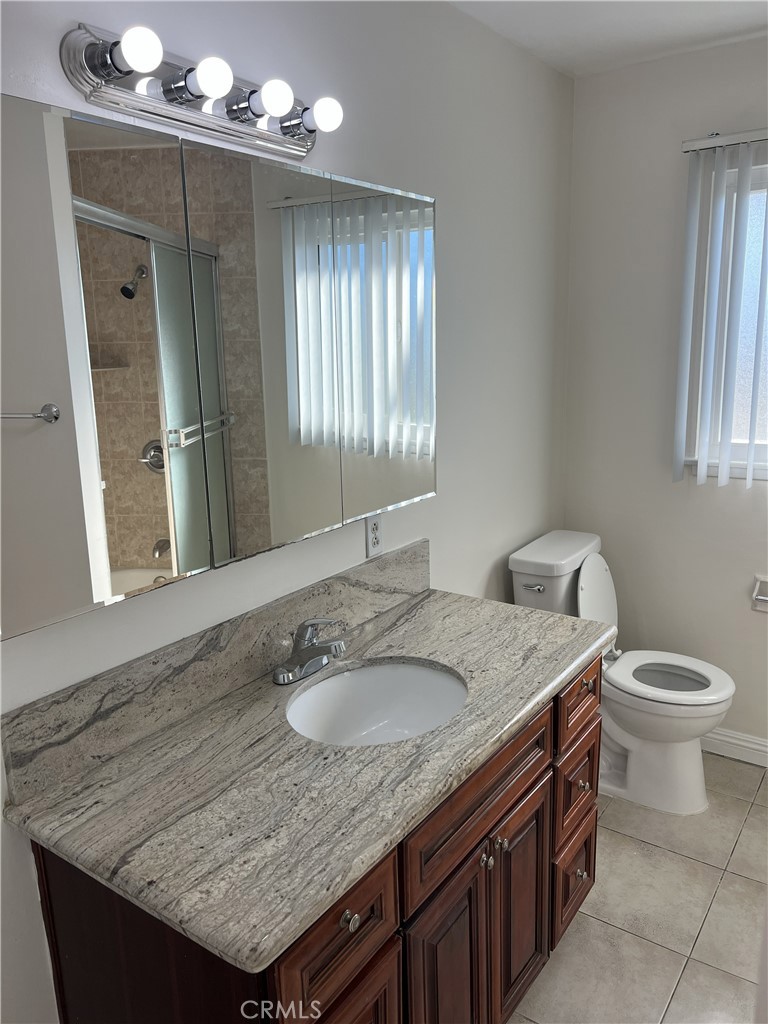 401 West Grand Avenue, Unit C Alhambra, CA 91801 - Photo 12 of 14 a bathroom with a granite countertop sink and a mirror