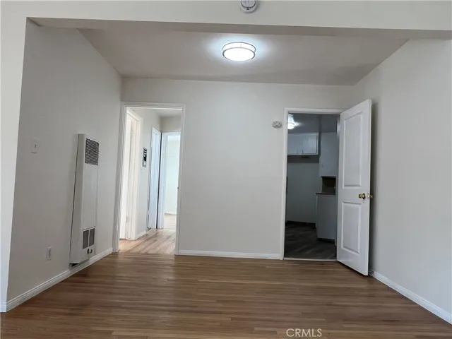 a view of an empty room with wooden floor