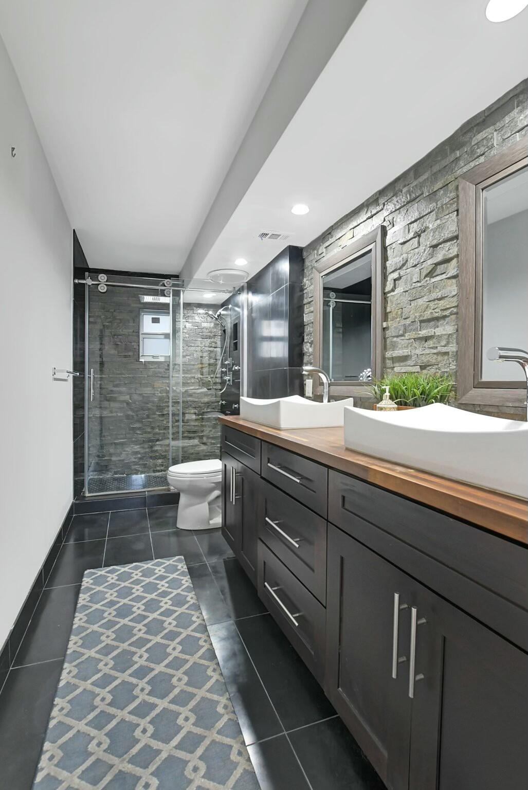 2871 North Ocean Boulevard, Unit V441 Boca Raton, FL 33431 - Photo 18 of 75 a bathroom with a double vanity sink toilet and shower