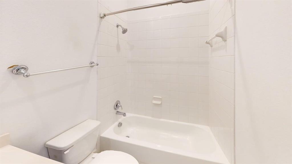 9628 Boulder Pt Road Oak Point, TX 75068 - Photo 20 of 35 Bathroom featuring a white bathtub, ceramic tile surround, and chrome fixtures
